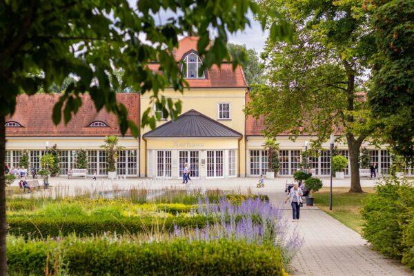 Kurhaus mit gepflegtem Garten als Symbolbild fuer Adipositas Rehaklinik Bayern