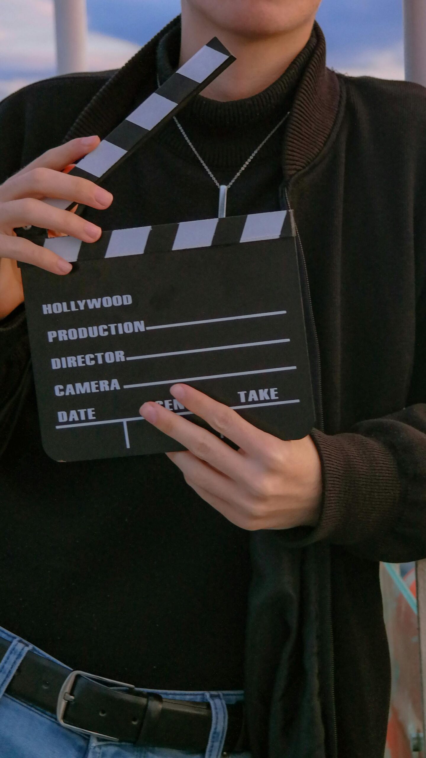Mann mit Filmklappe als Symbolbild fuer Hochschule fuer Film und Fernsehen Muenchen
