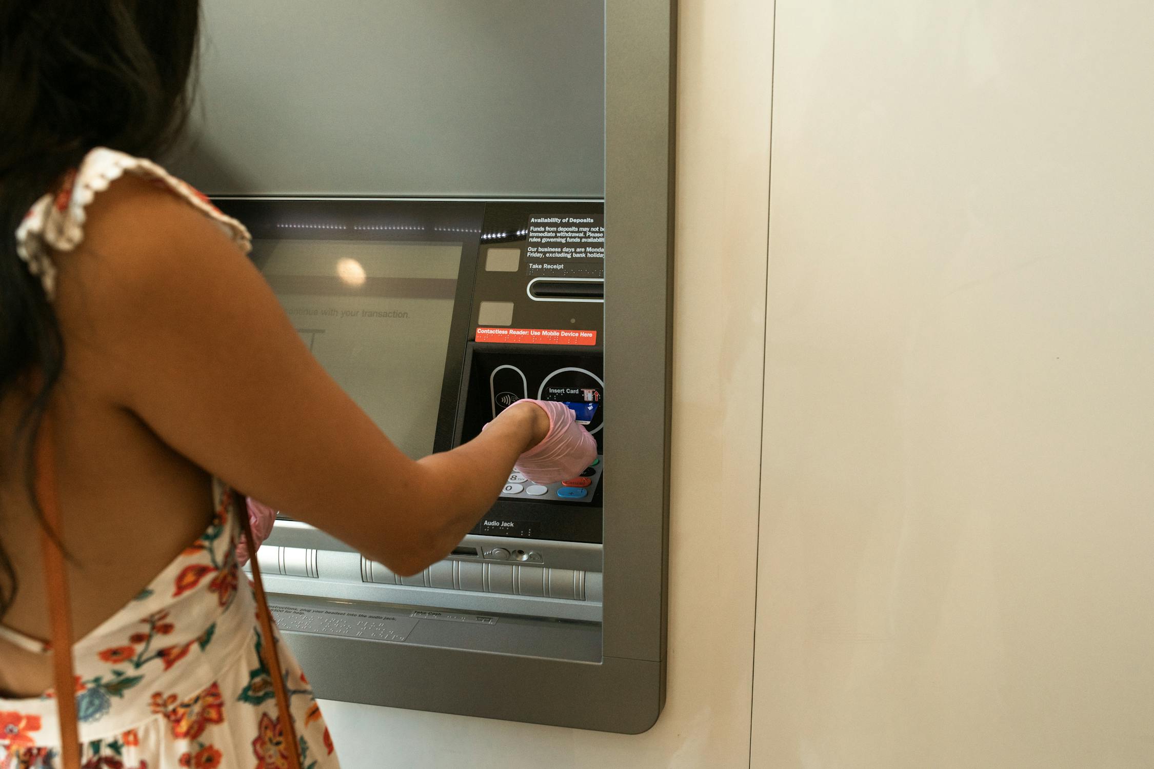 Frau am Geldautomaten - Symbolbild Genossenschaftsbanken Bayern