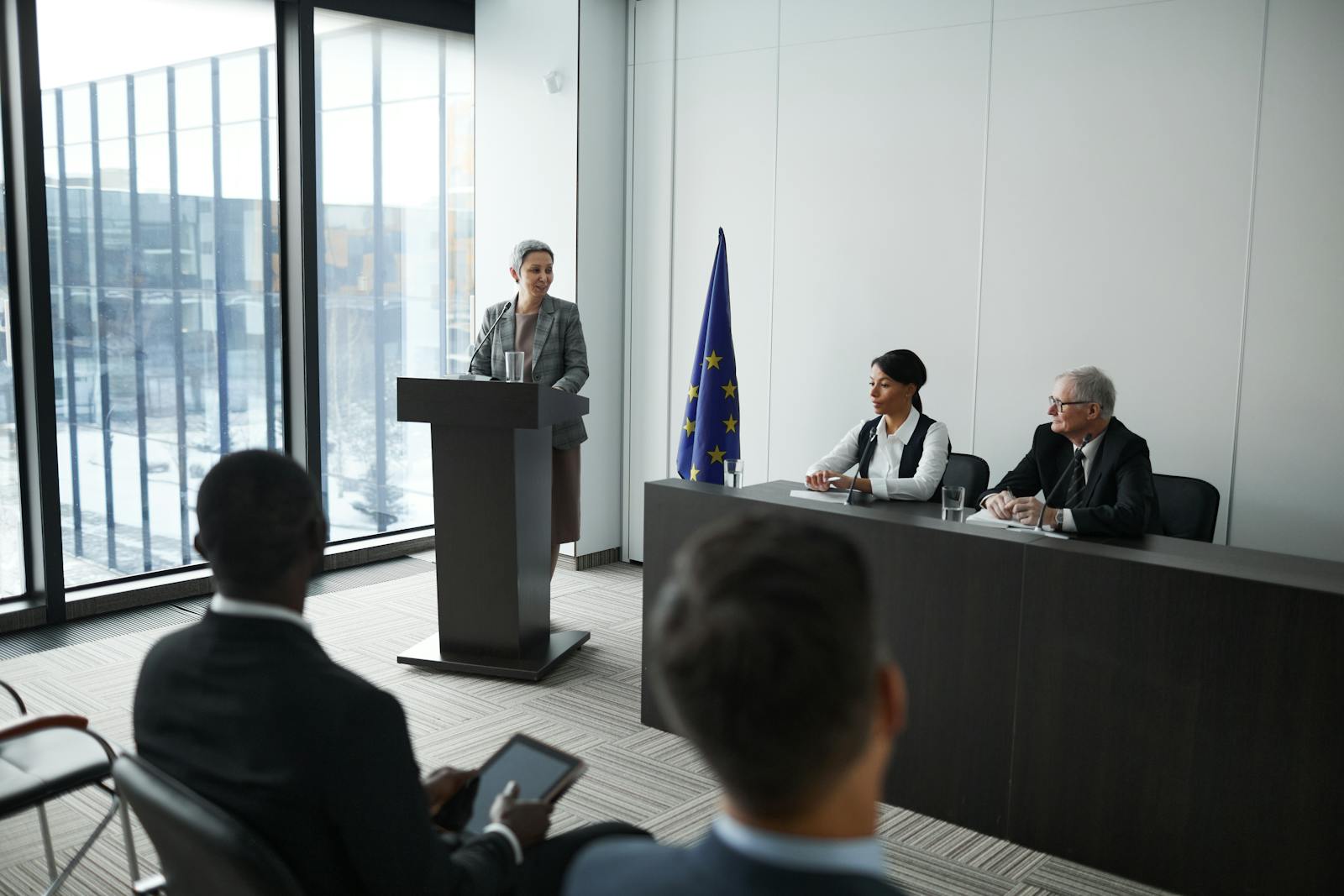 Rednerin am Podium mit EU-Flagge als Symbolbild fuer Landtagsabgeordnete Bayern Verguetung