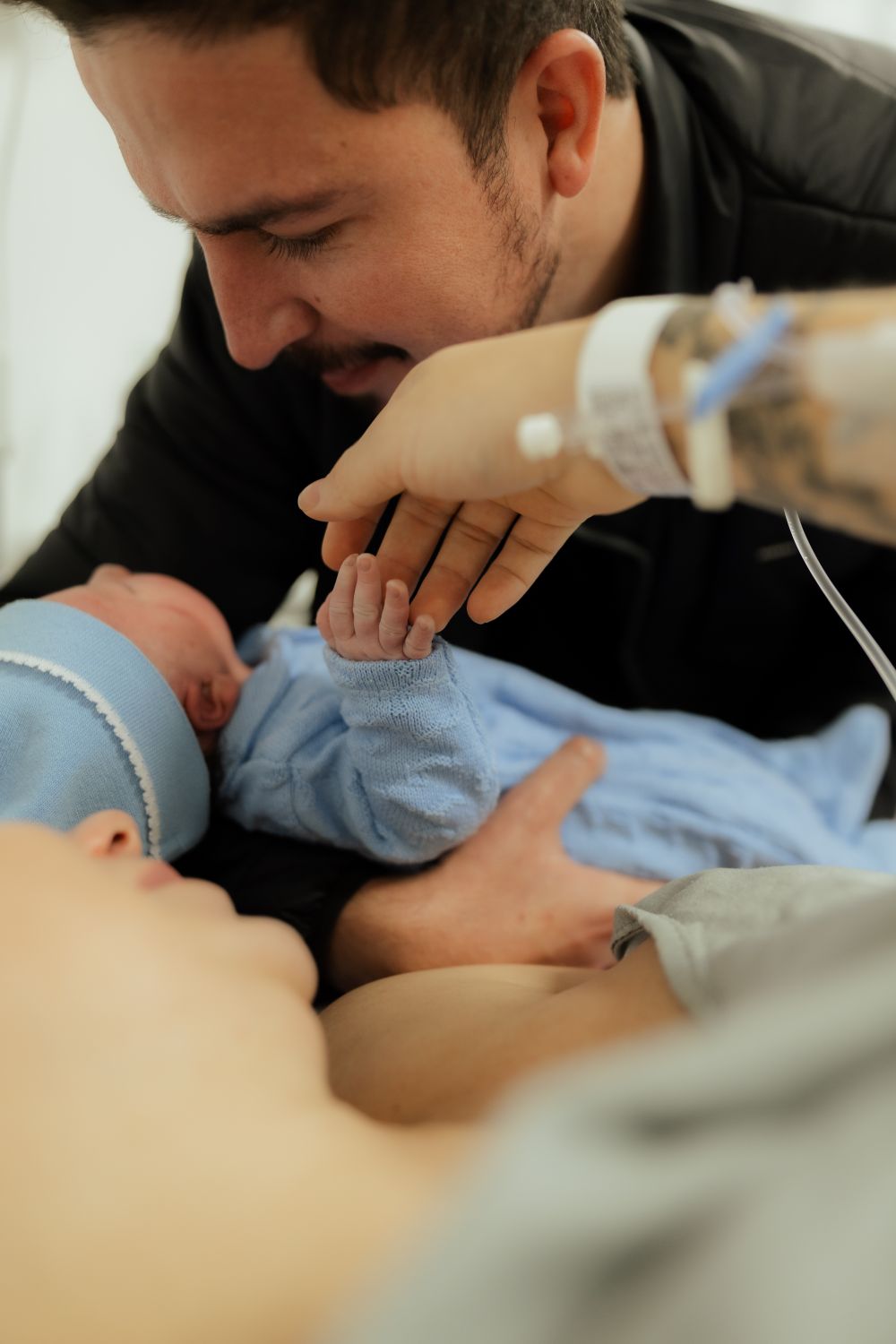 Vater hält Neugeborenes im Krankenhaus - Symbolbild Geburtenrückgang Bayern 2025