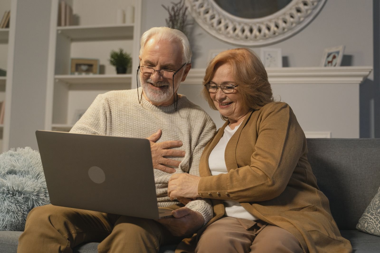 Aelteres Paar prueft gemeinsam Unterlagen am Laptop